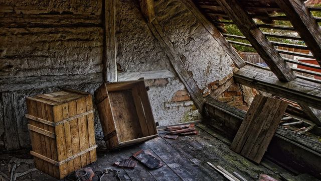 Alte Holzkisten auf einem verfallenen Dachboden