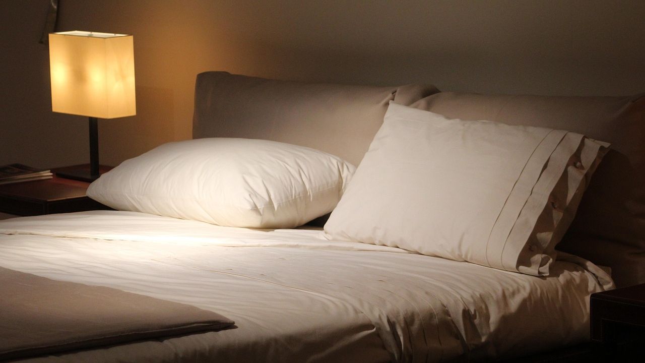 Doppelbett mit Kissen und Nachttischlampe