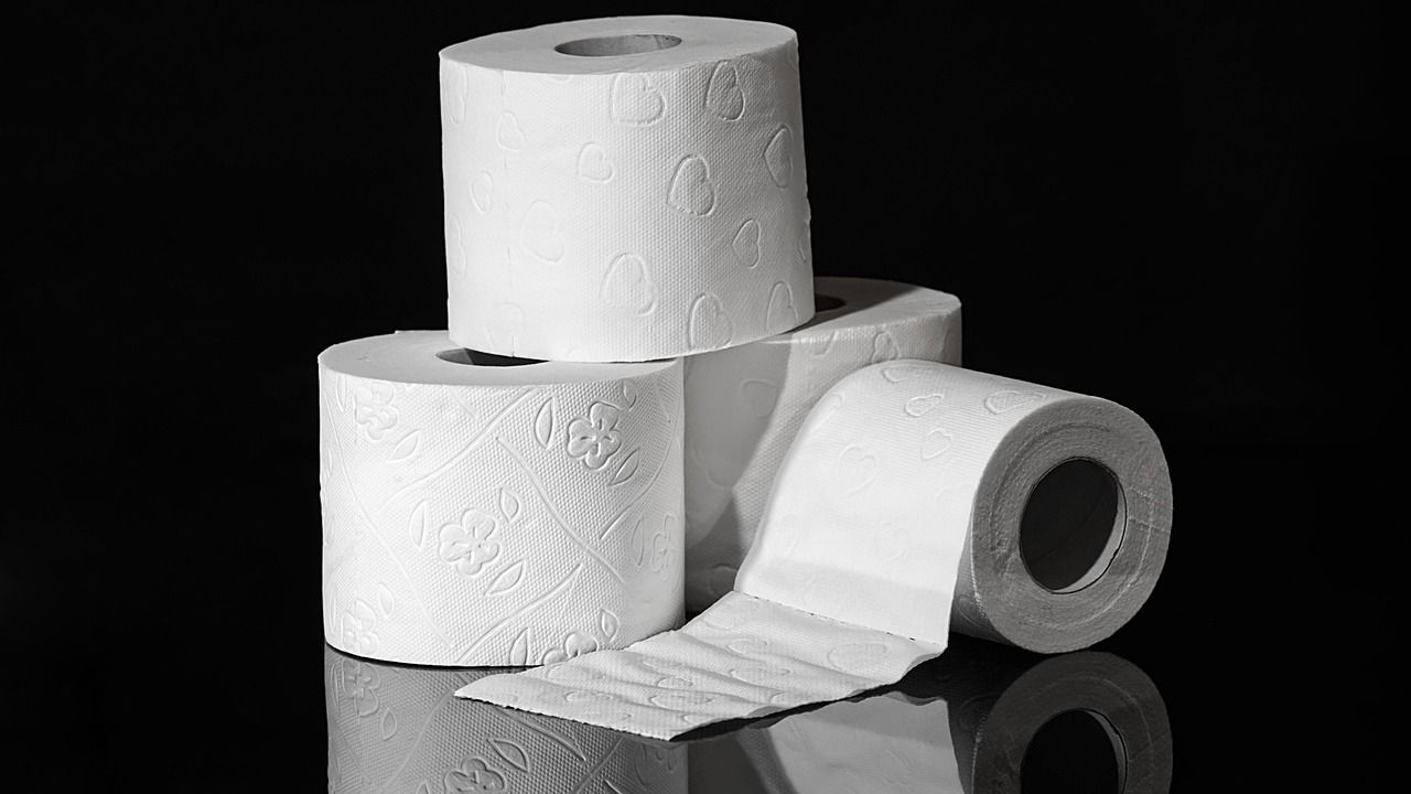 Rollen Toilettenpapier vor schwarzem Hintergrund